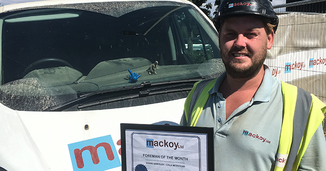 Mackoy Groundworks Operative with Award in Front of Branded Mackoy Van