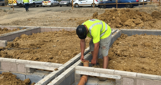 Mackoy Ltd Foreman on Groundworks site installing Drains in Foundations